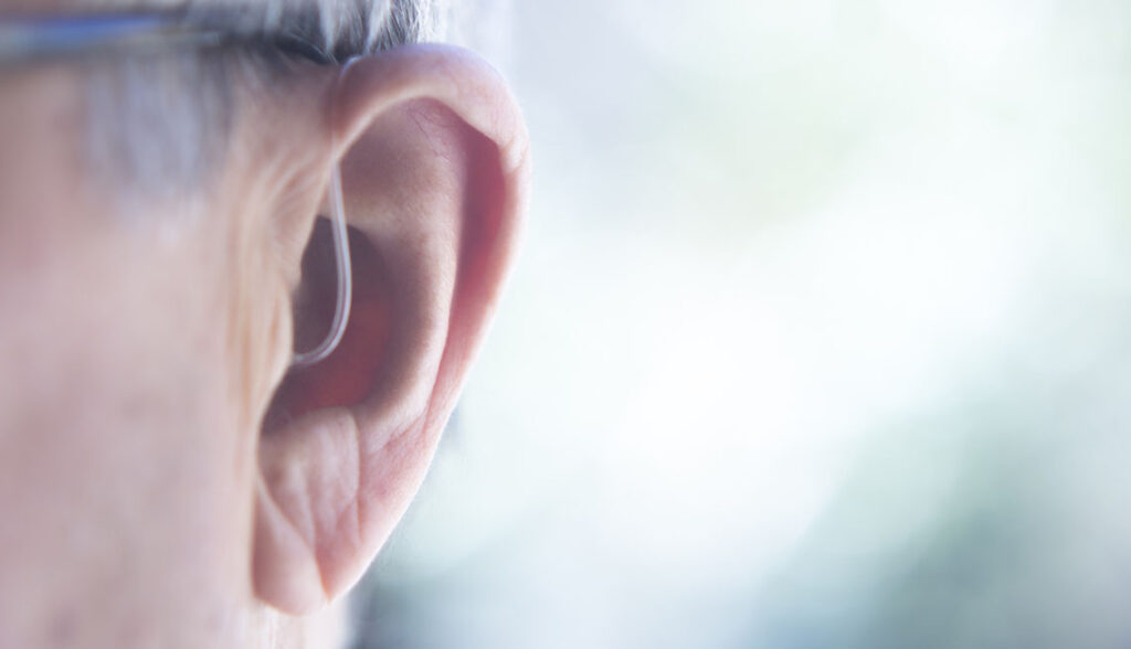 1140 hearing aid man closeup blurred